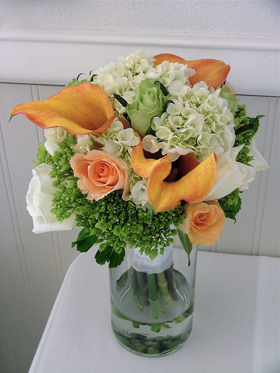 A wedding bouquet of roses, hydrangea and calla lilies